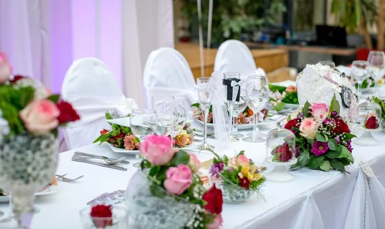 Una mesa de banquete con flores de temporada y copas