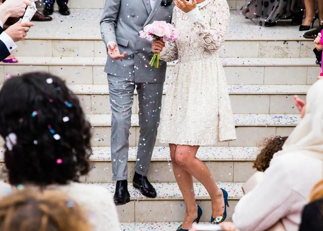 La salida de los novios, entre pétalos, bajando la escalera