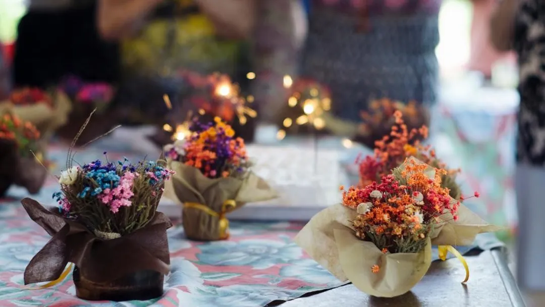 Una mesa con flores al aire libre, de día