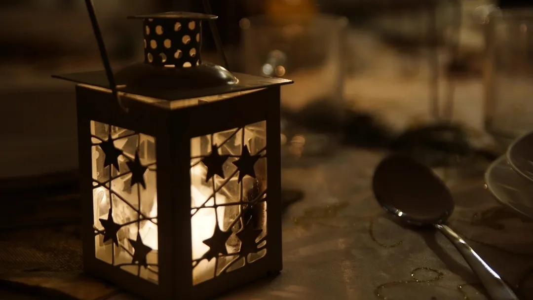 Un farol encendido en la mesa, de noche